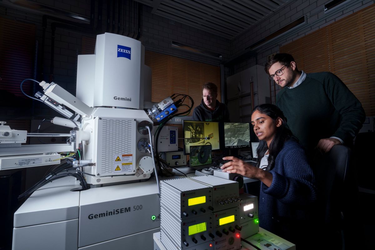 Researchers at a scanning electron microscope examining a keratin sample
